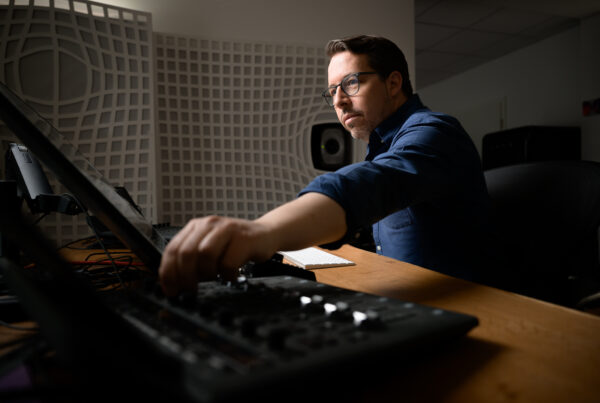 Eric Horstmann mixing at his Immersive Lab studio with his hand on a controller