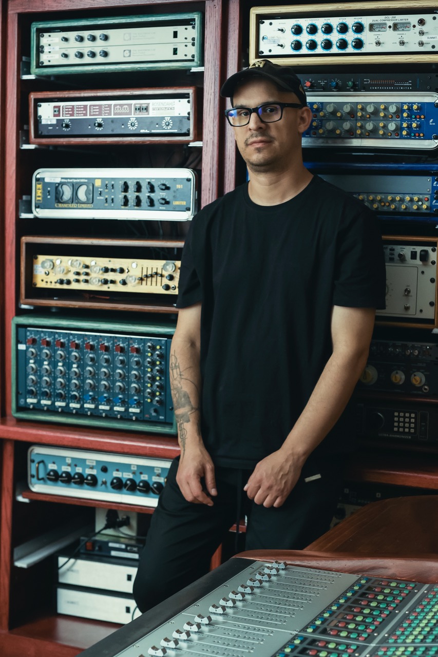 Superman recording and mixing engineer Justin Moshkevich standing in front of equipment at Igloo Music.