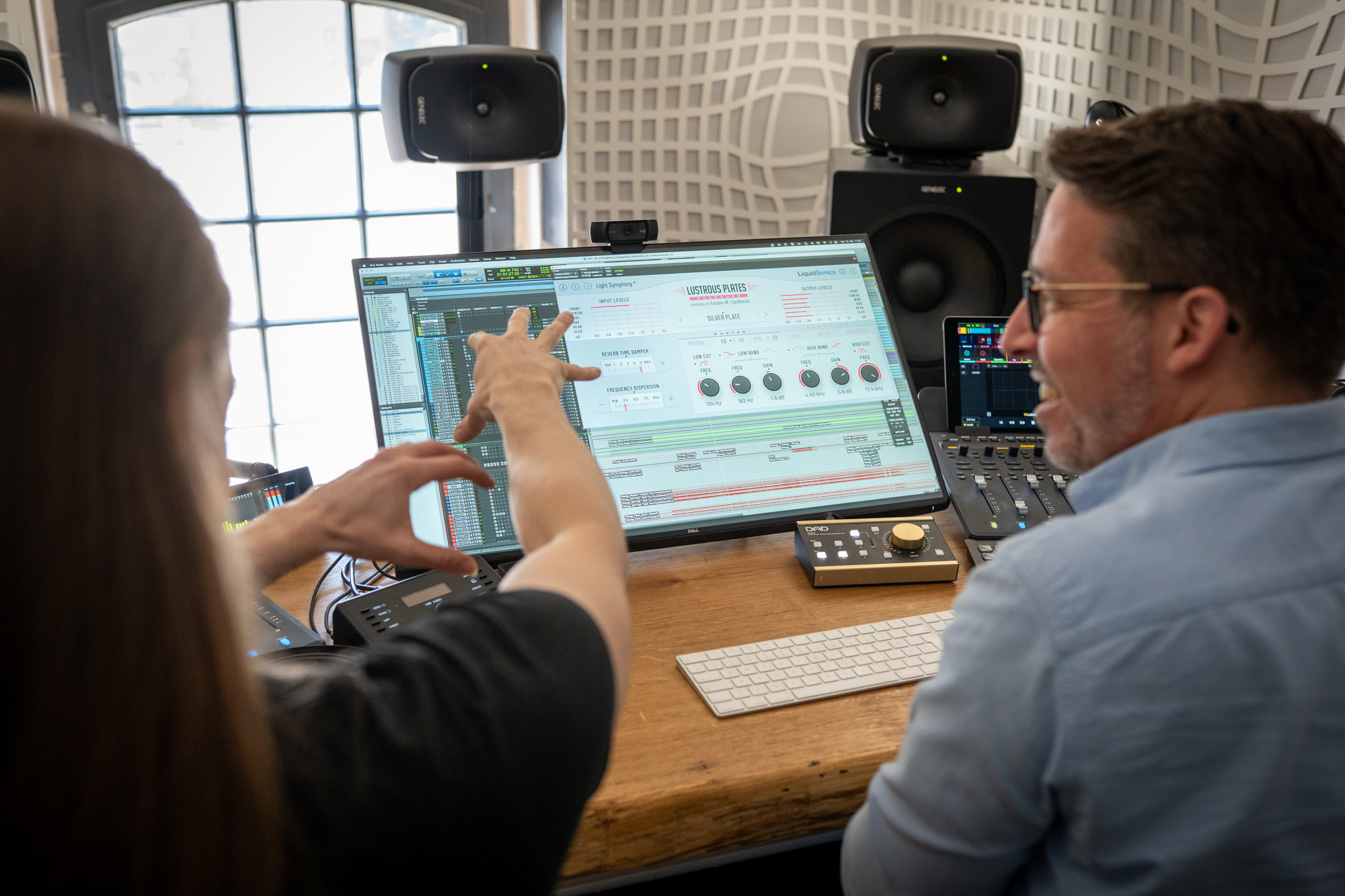 Tom Fountainhead and Eric Horstmann looking at a computer screen with LiquidSonics' Lustrous Plates Surround plugin.